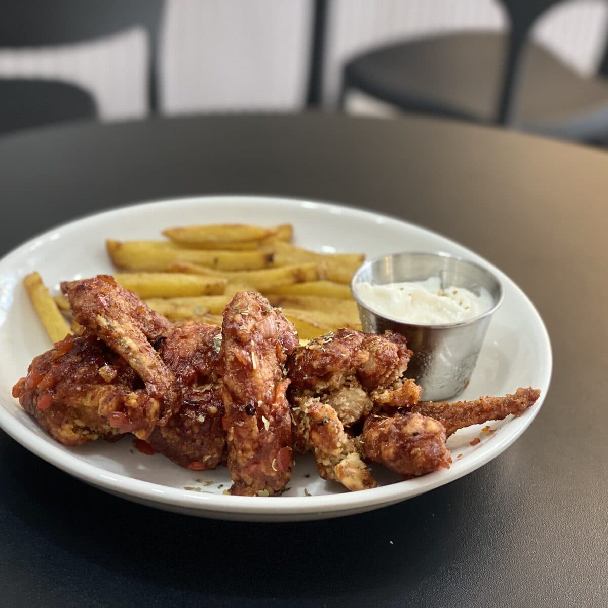 Glazed chicken wings served with fries and a dip